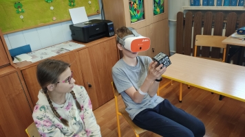 uczniowie w okularach VR oglądają kostkę, prezentację na temat Zespołu Downa