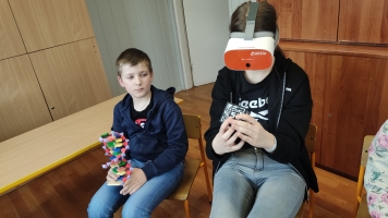uczniowie w okularach VR oglądają kostkę, prezentację na temat Zespołu Downa